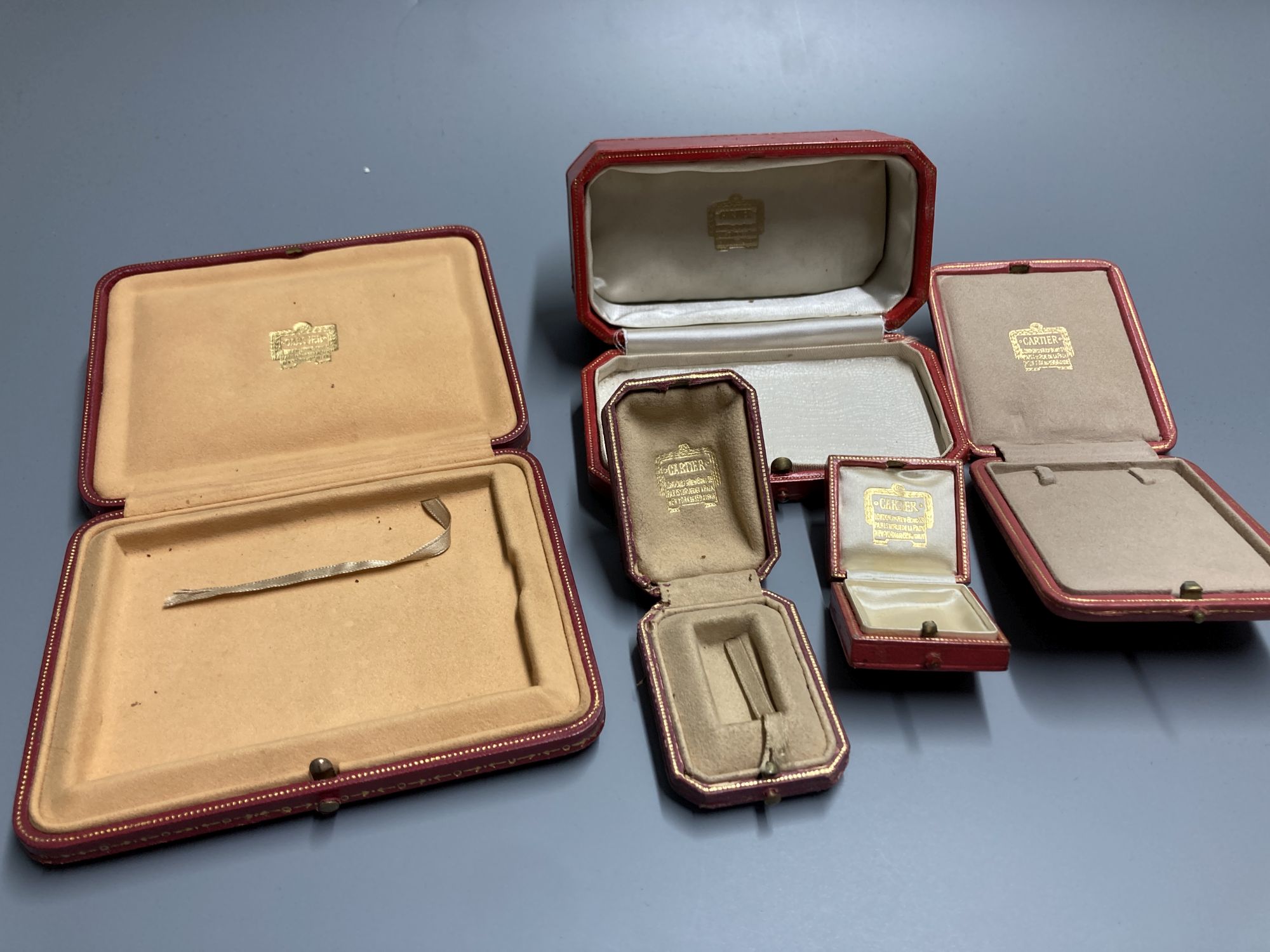 Five assorted Cartier gilt tooled leather jewellery boxes, largest 13.5cm.